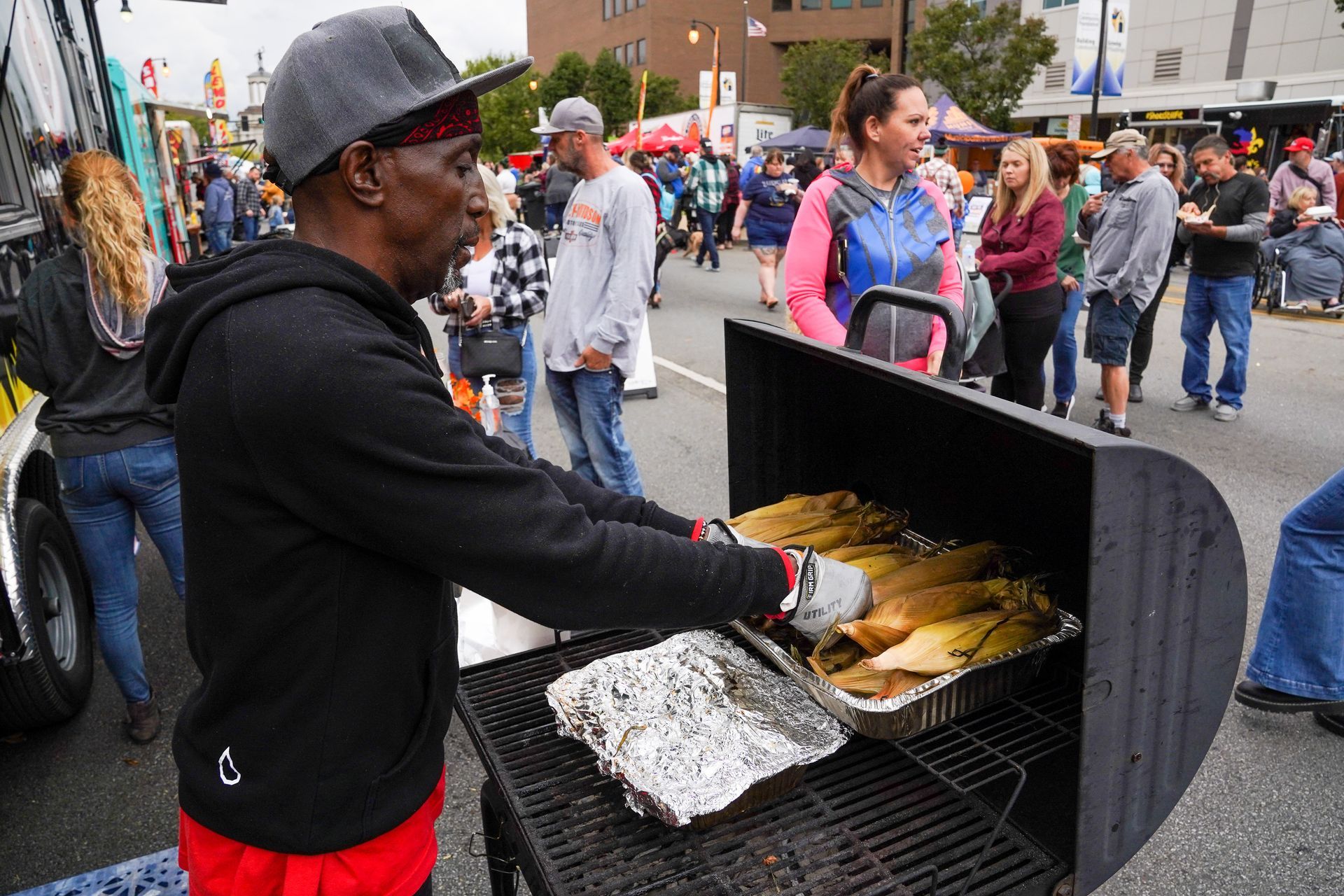 a man is cooking corn on the cob on a grill