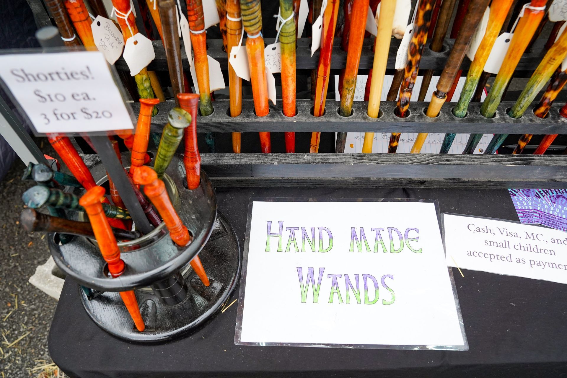 a table with a sign that says hand made wands on it