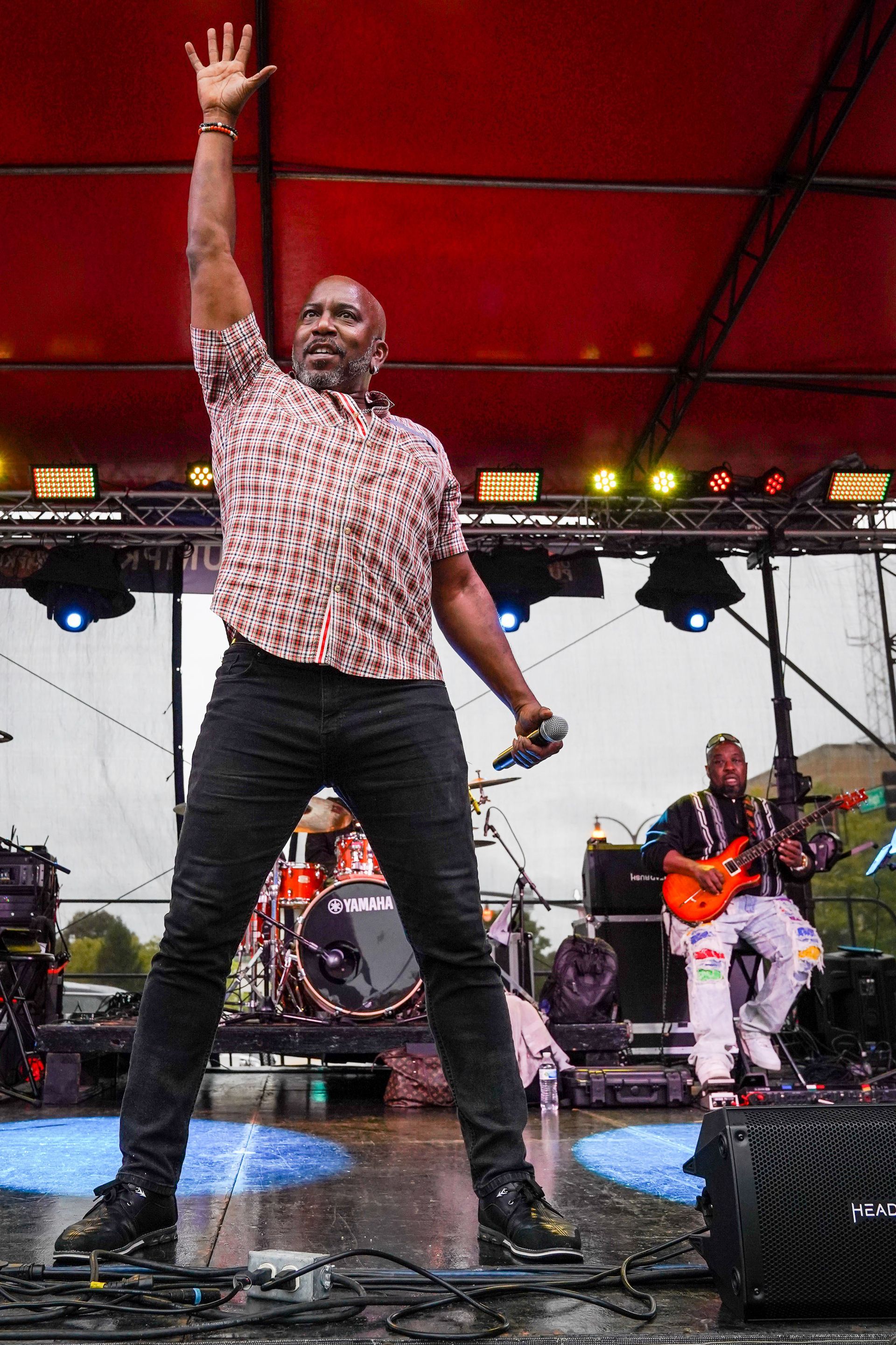a man is standing on a stage with his hand in the air
