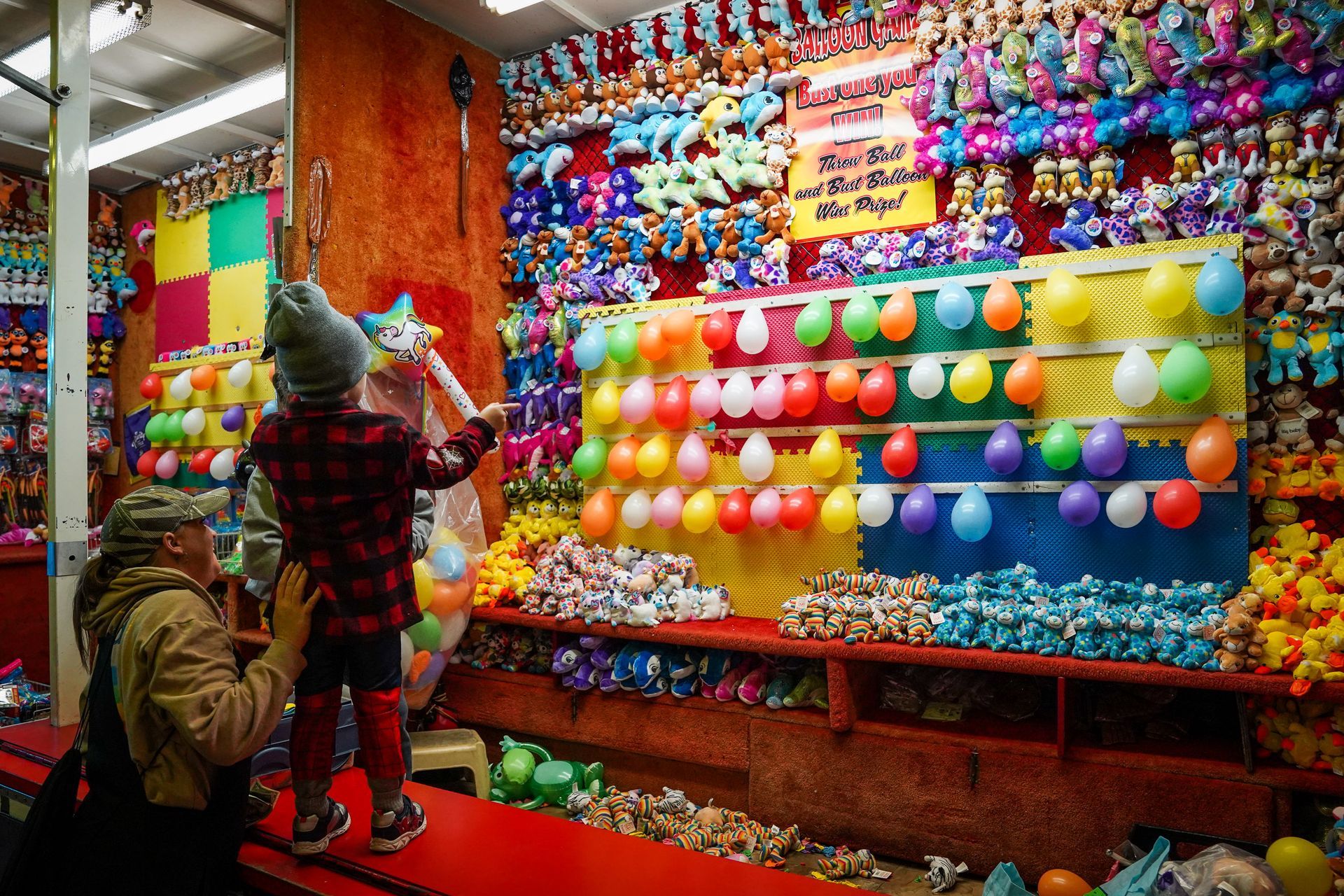 a man and a child are playing a game at a carnival
