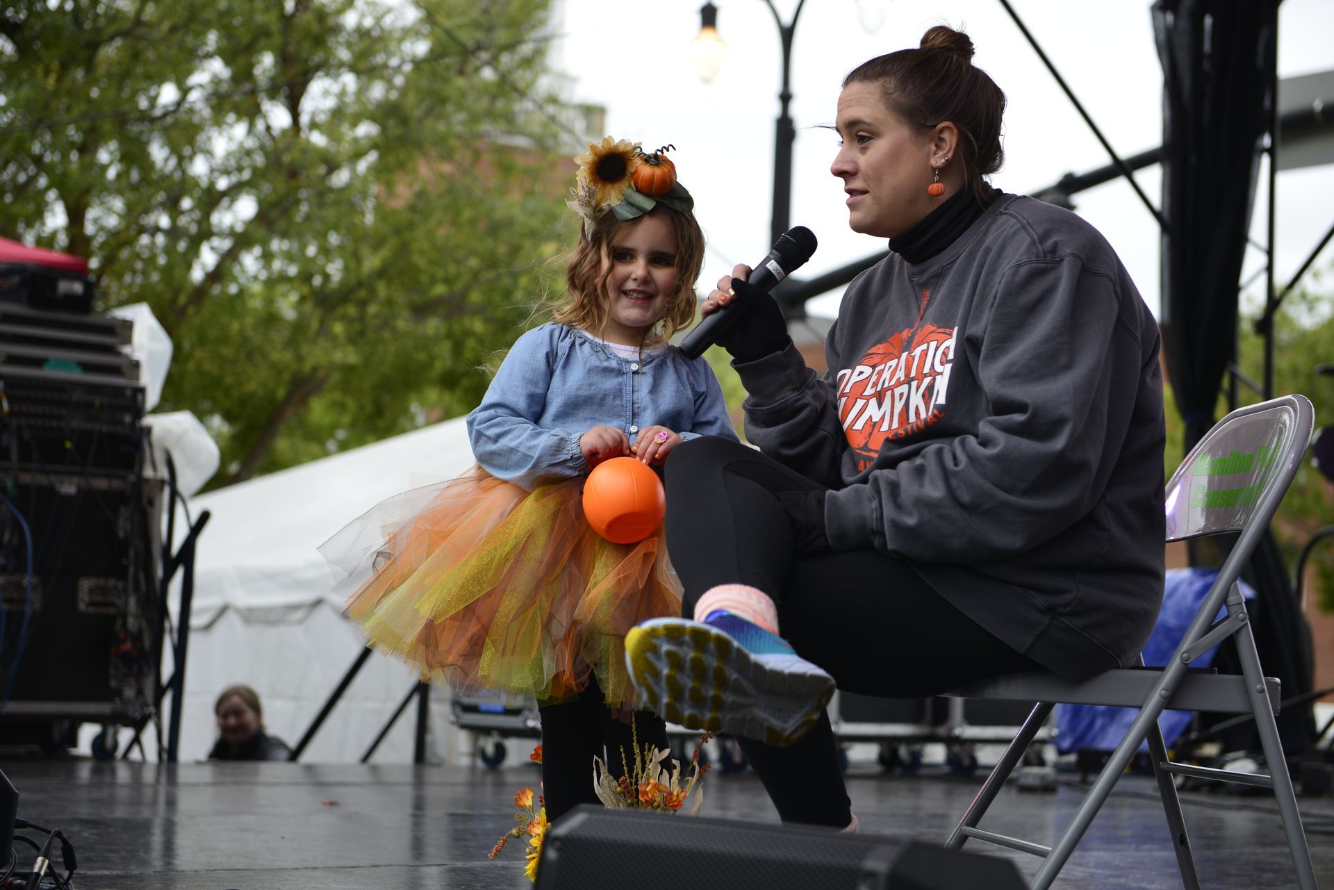 woman interviewing a kid in yellow tutu dress