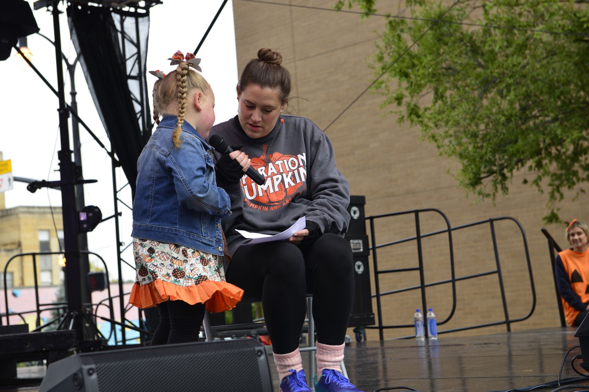 woman interviewing a kid on a stage