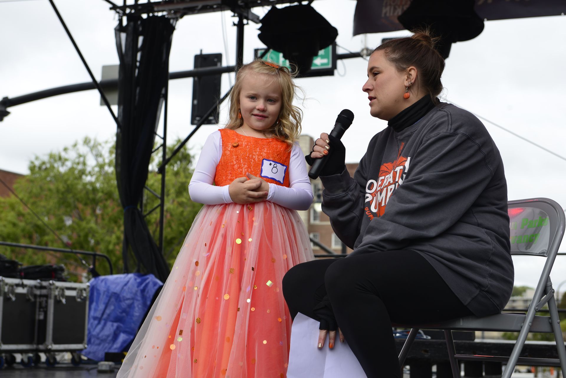 a woman is sitting next to a little girl holding a microphone