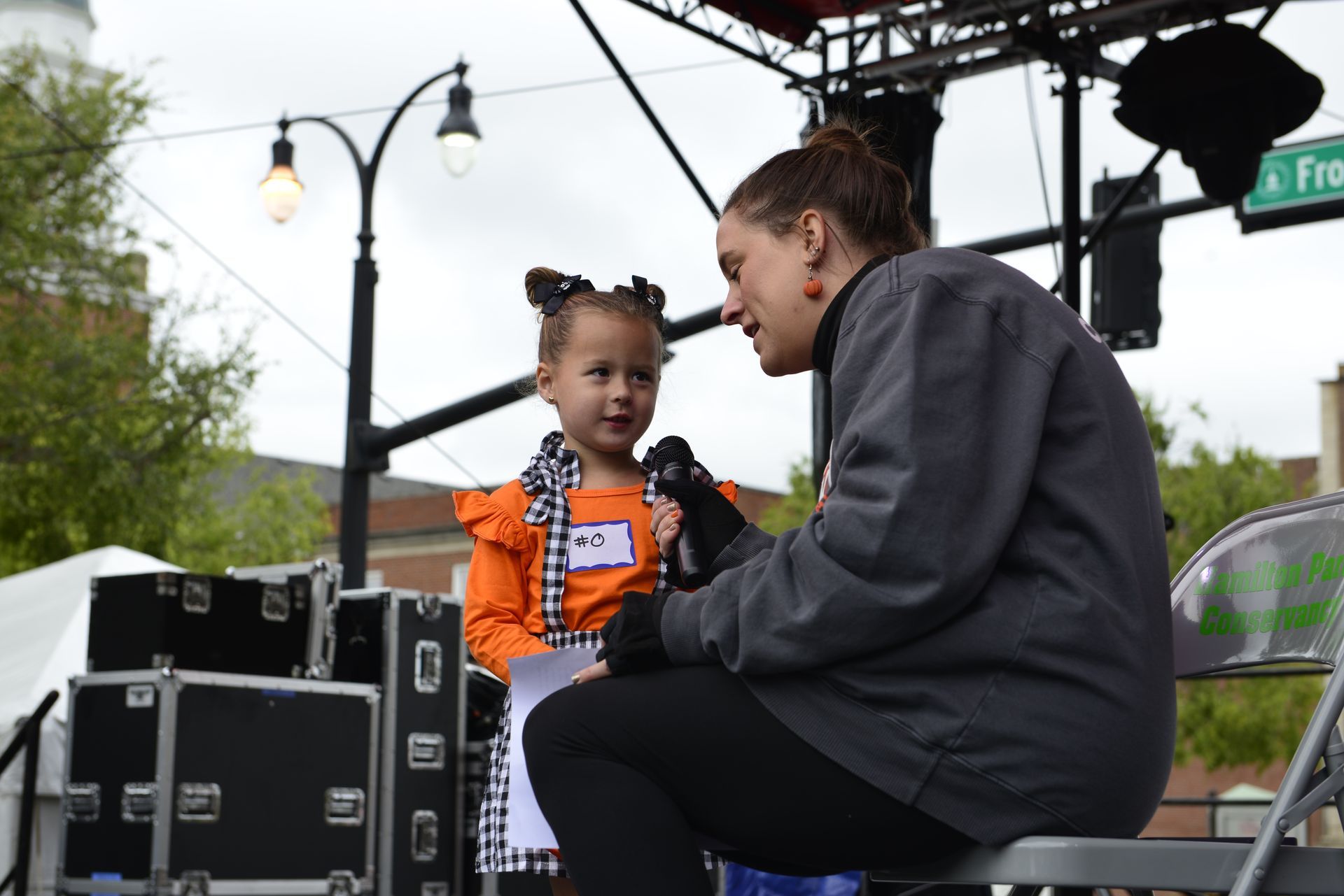 a woman is kneeling down next to a little girl holding a microphone