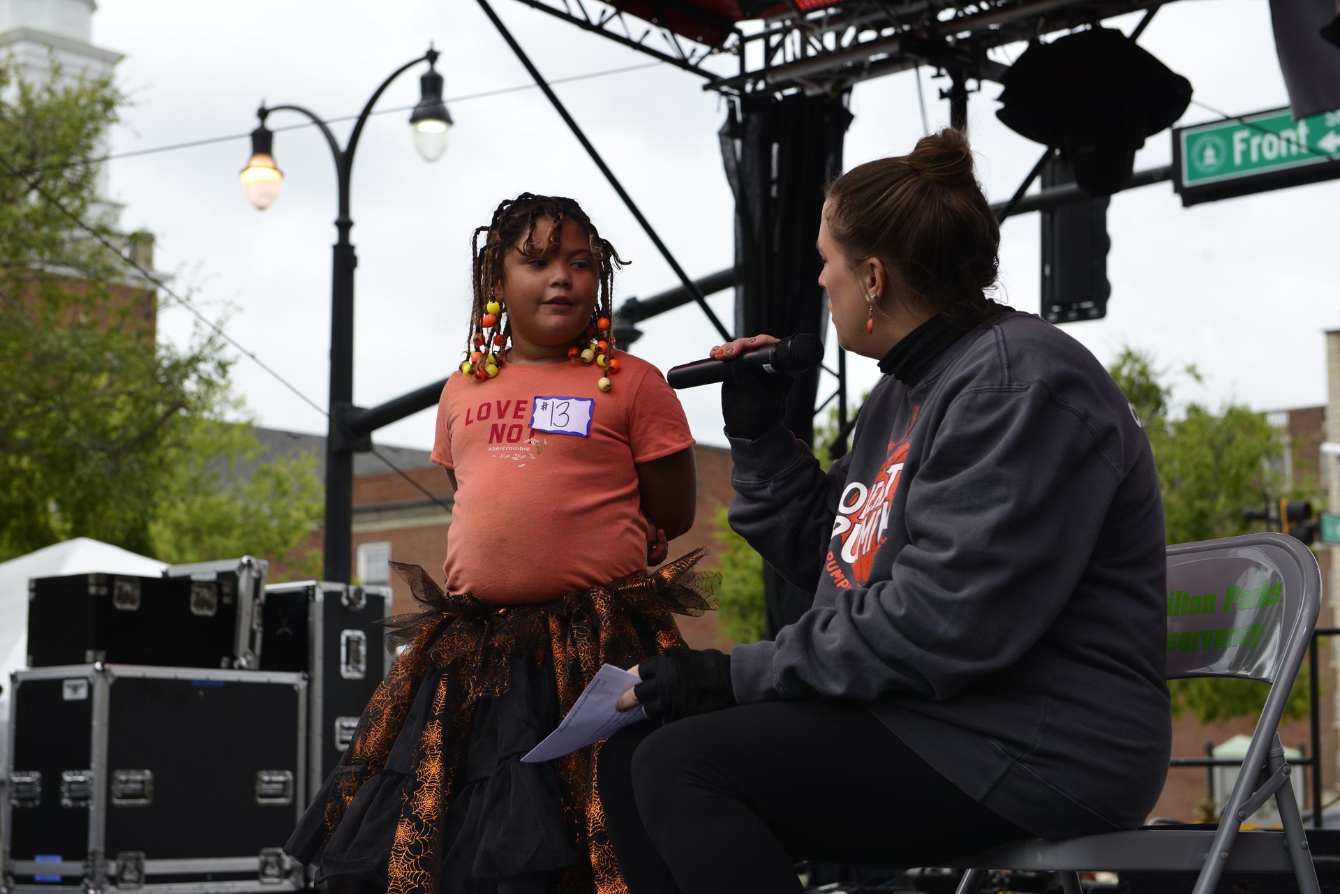 a woman is talking to a little girl on a stage