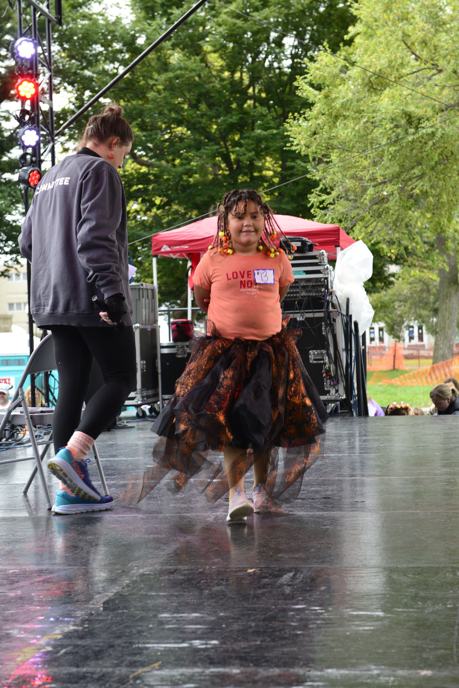 a little girl is dancing on a stage in the rain