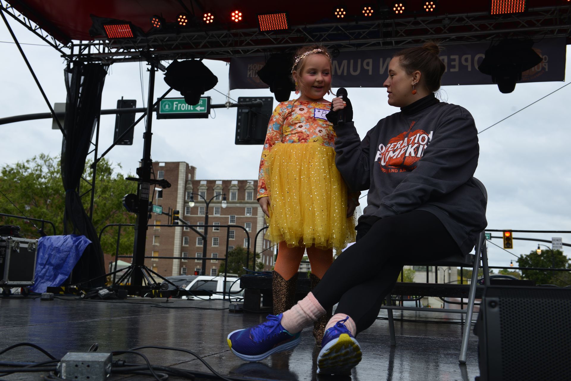 a woman is sitting next to a little girl on a stage