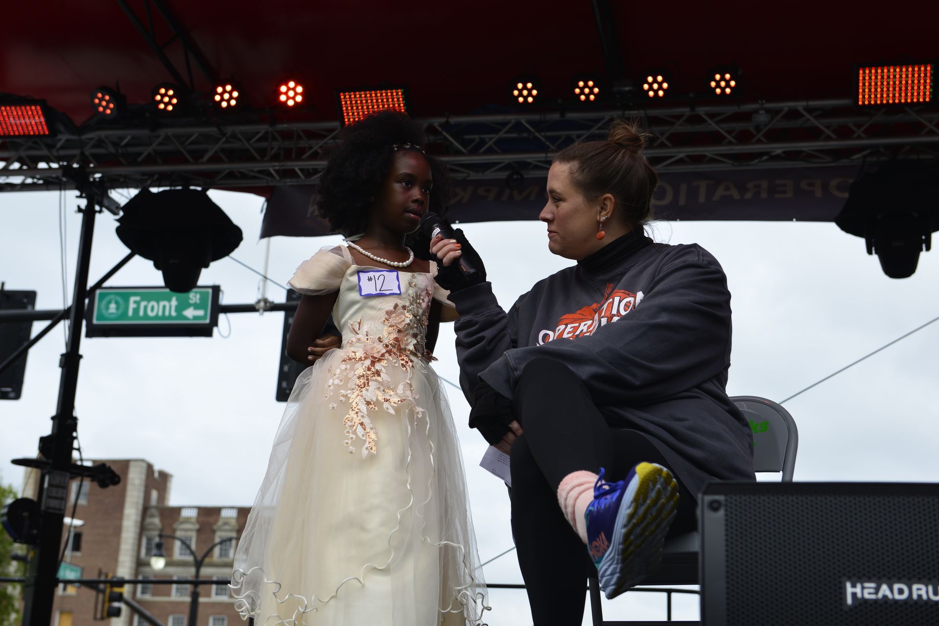 a woman sitting next to a girl in a white dress