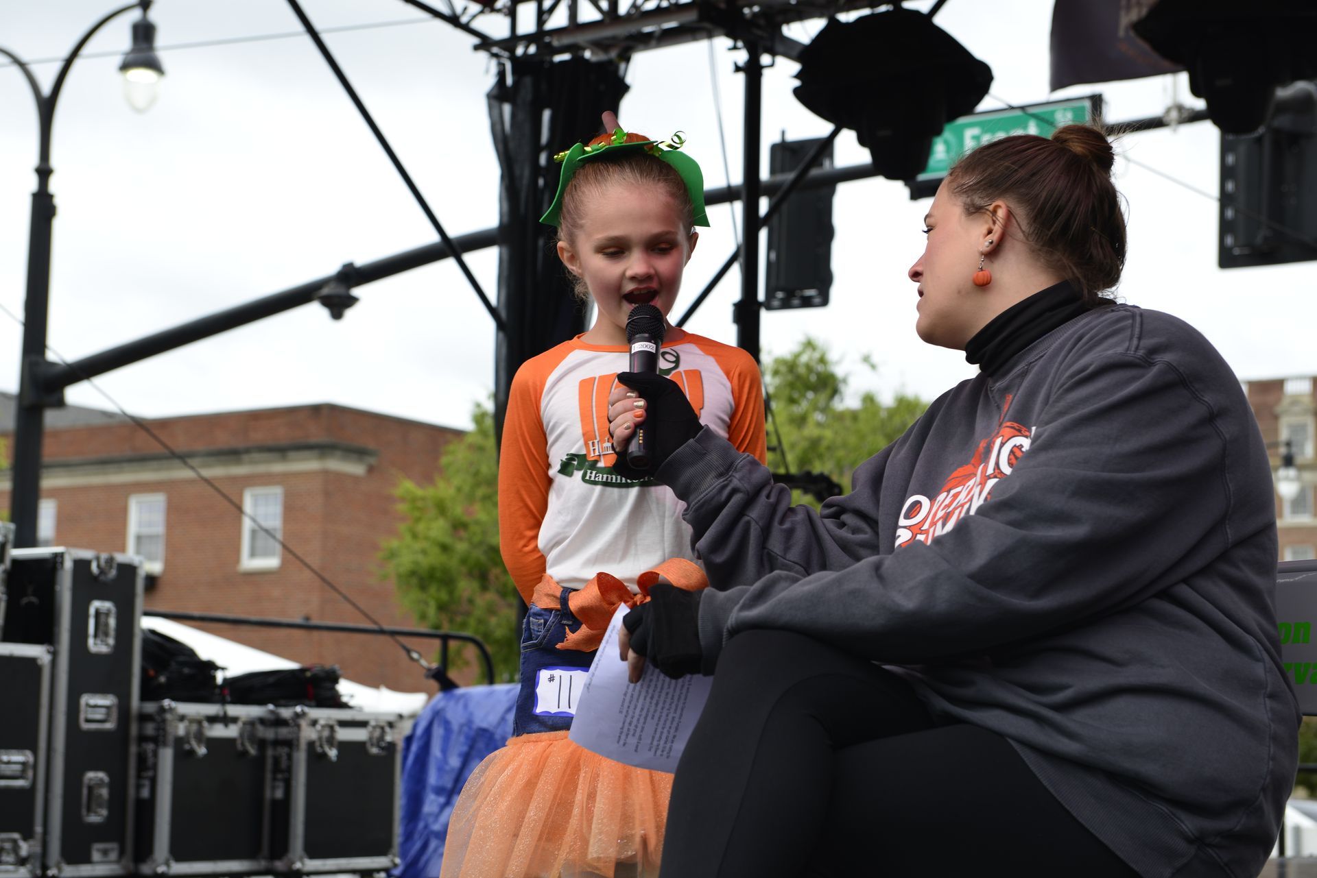 a woman sitting next to a little girl holding a microphone