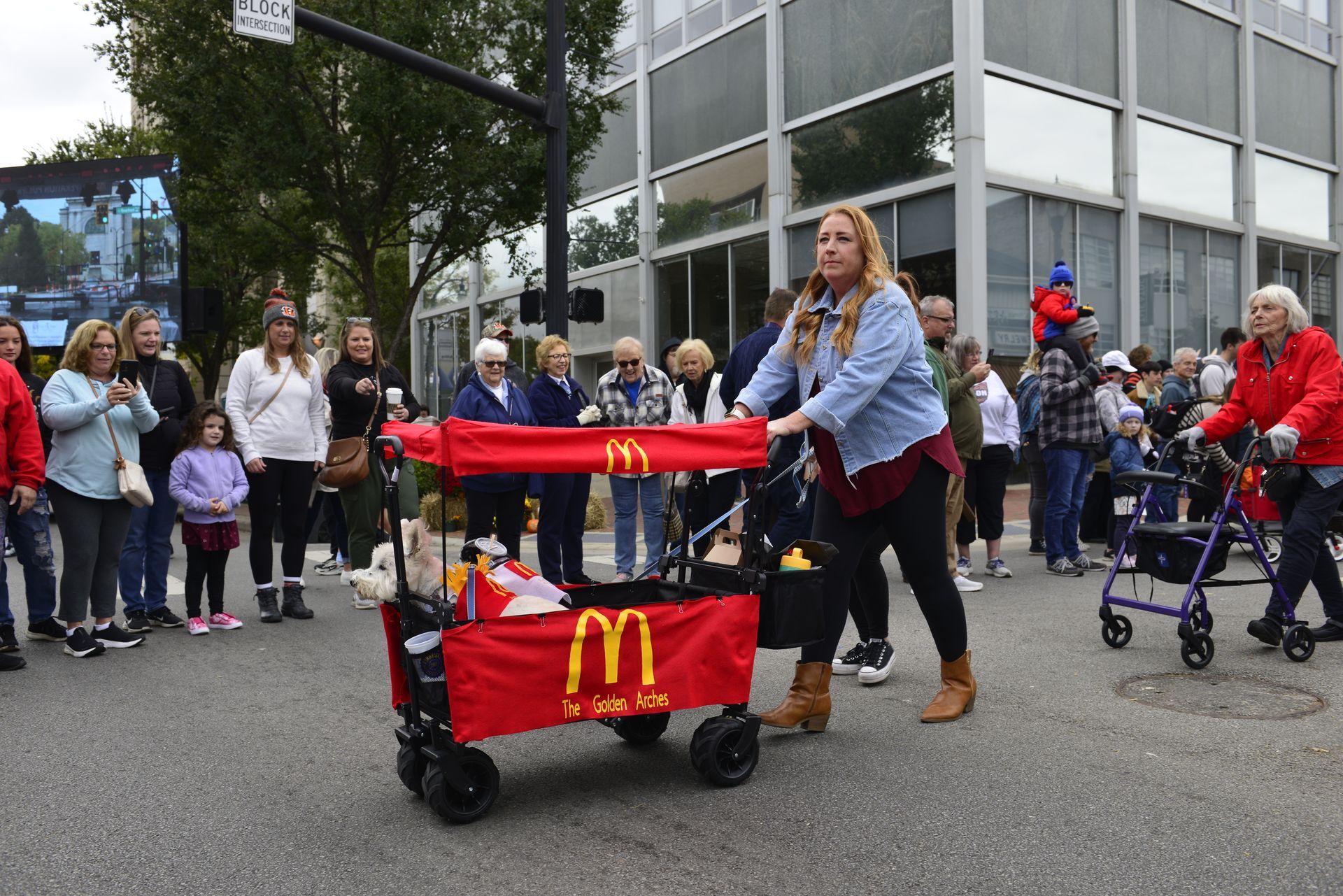 a woman is pushing a wagon with a McDonald's logo on it