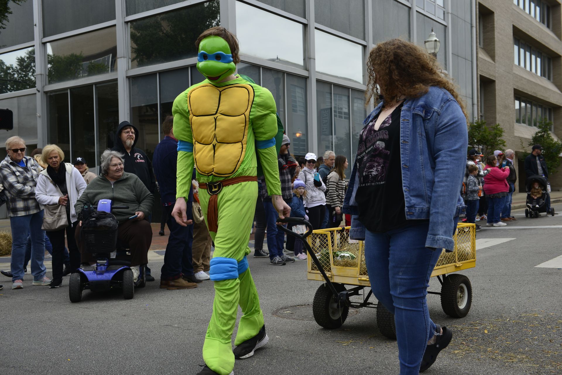 a man in a teenage mutant ninja turtle costume is walking down the street