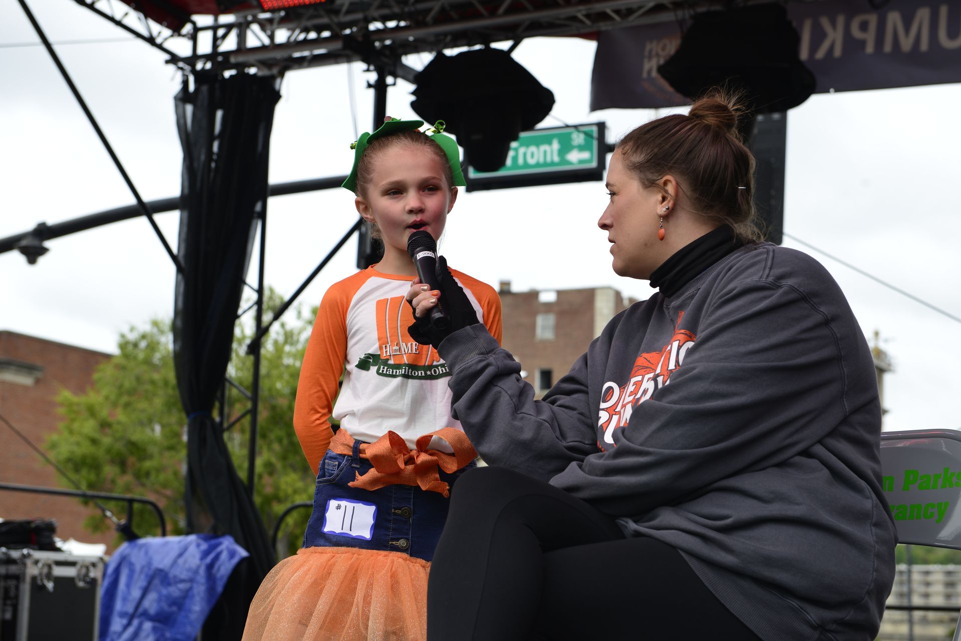 a woman is talking to a little girl who is holding a microphone