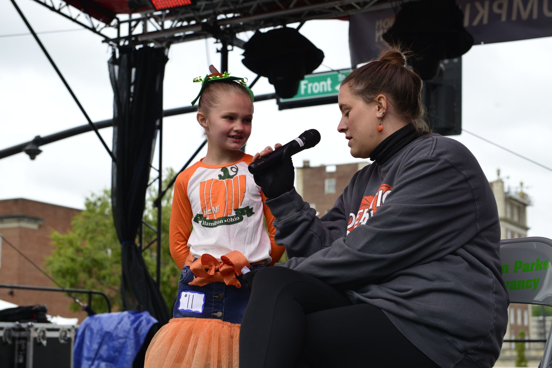 a woman is sitting next to a little girl holding a microphone