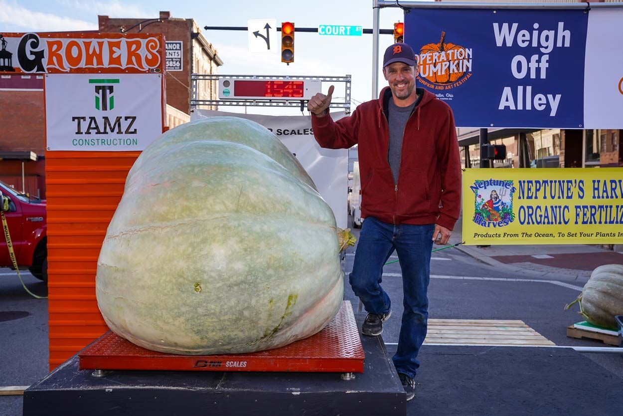 Man standing beside the pumpkin