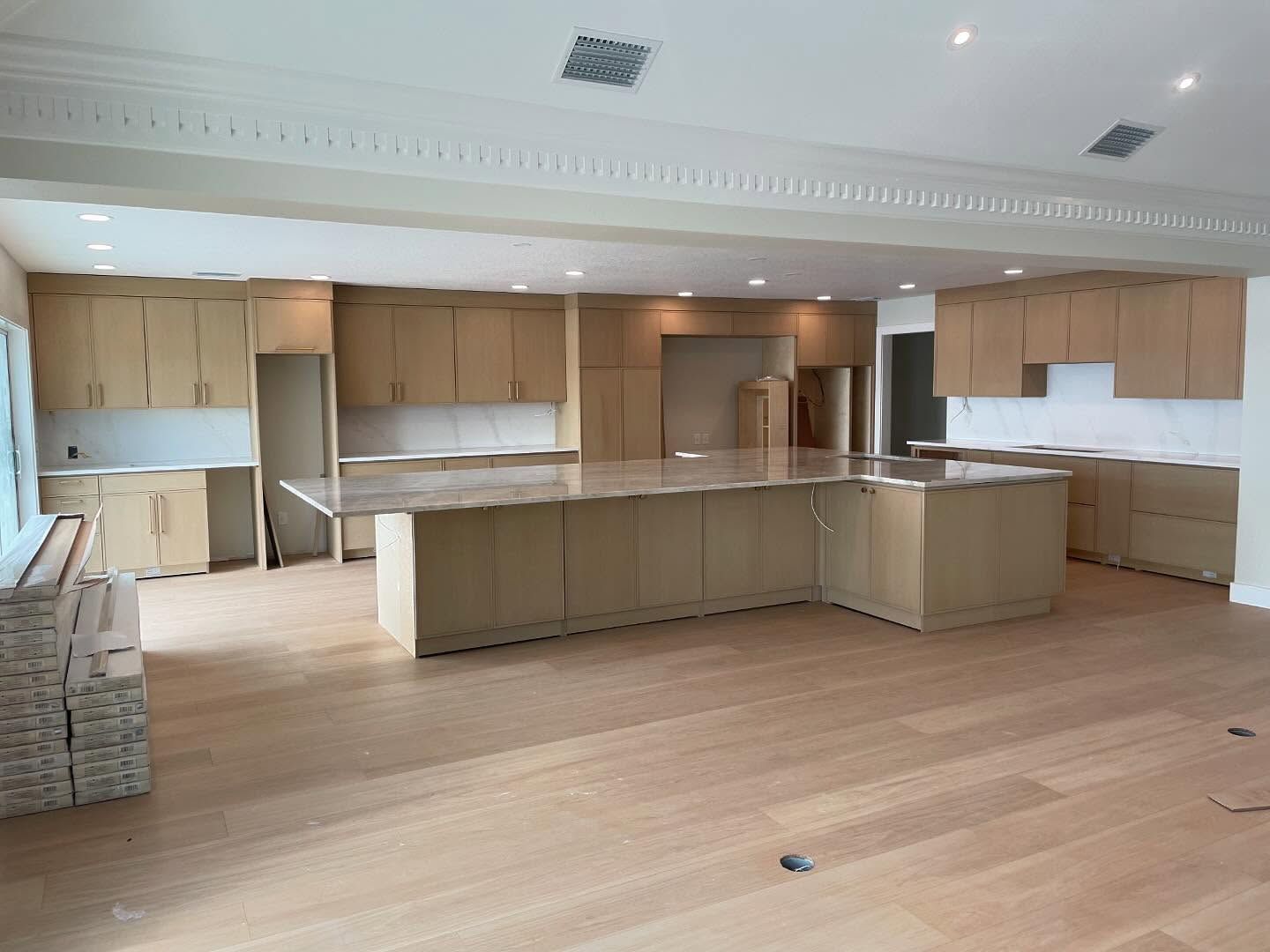A large empty kitchen with wooden cabinets and granite counter tops.