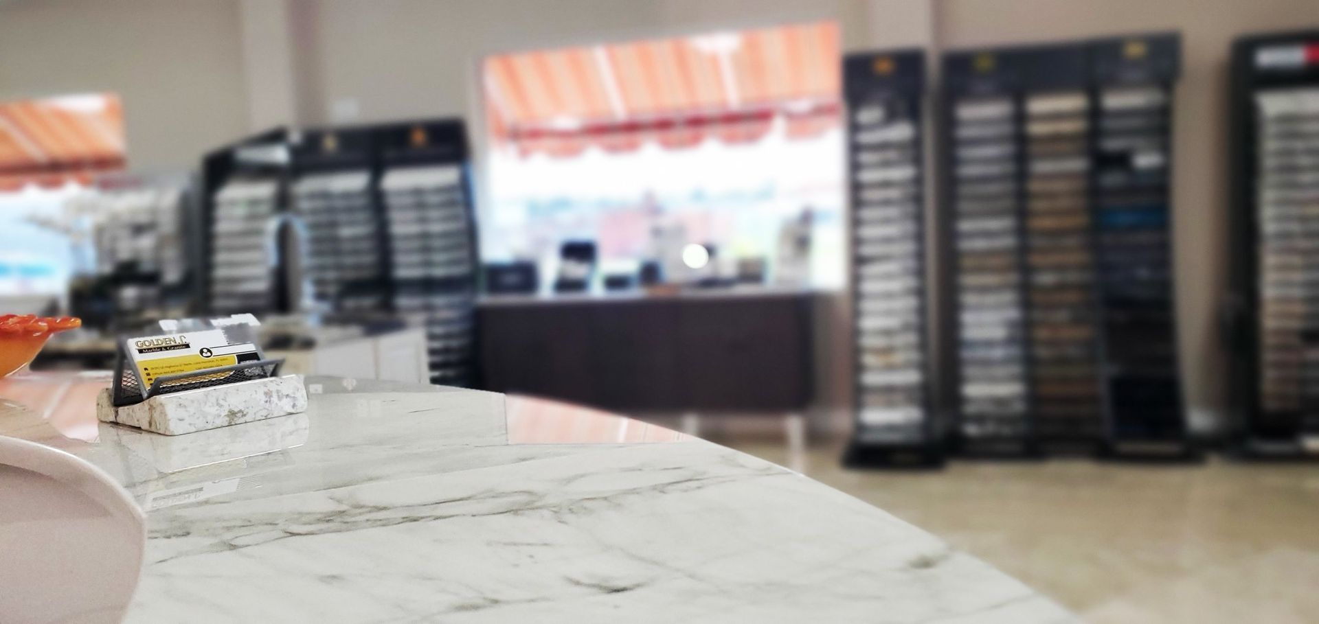 A marble counter top in a store with a vase on it.