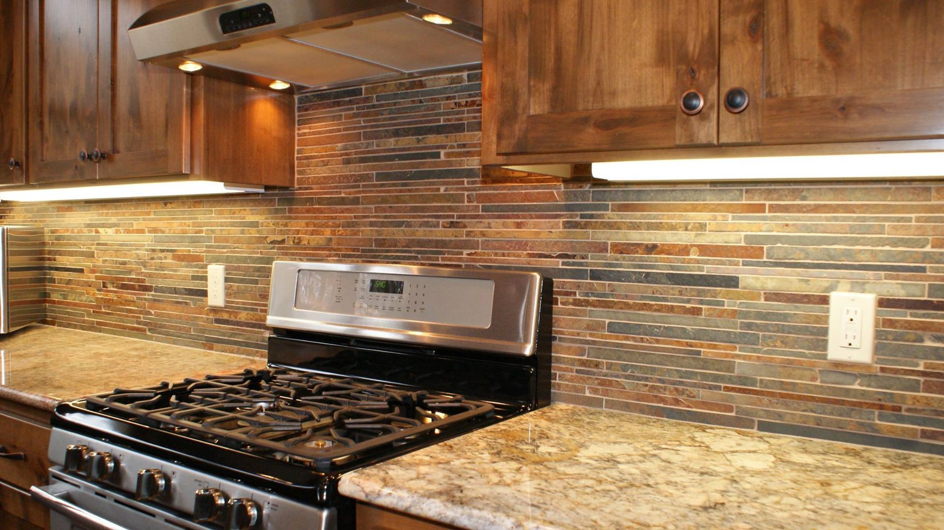 A kitchen with a stove top oven and granite counter tops.