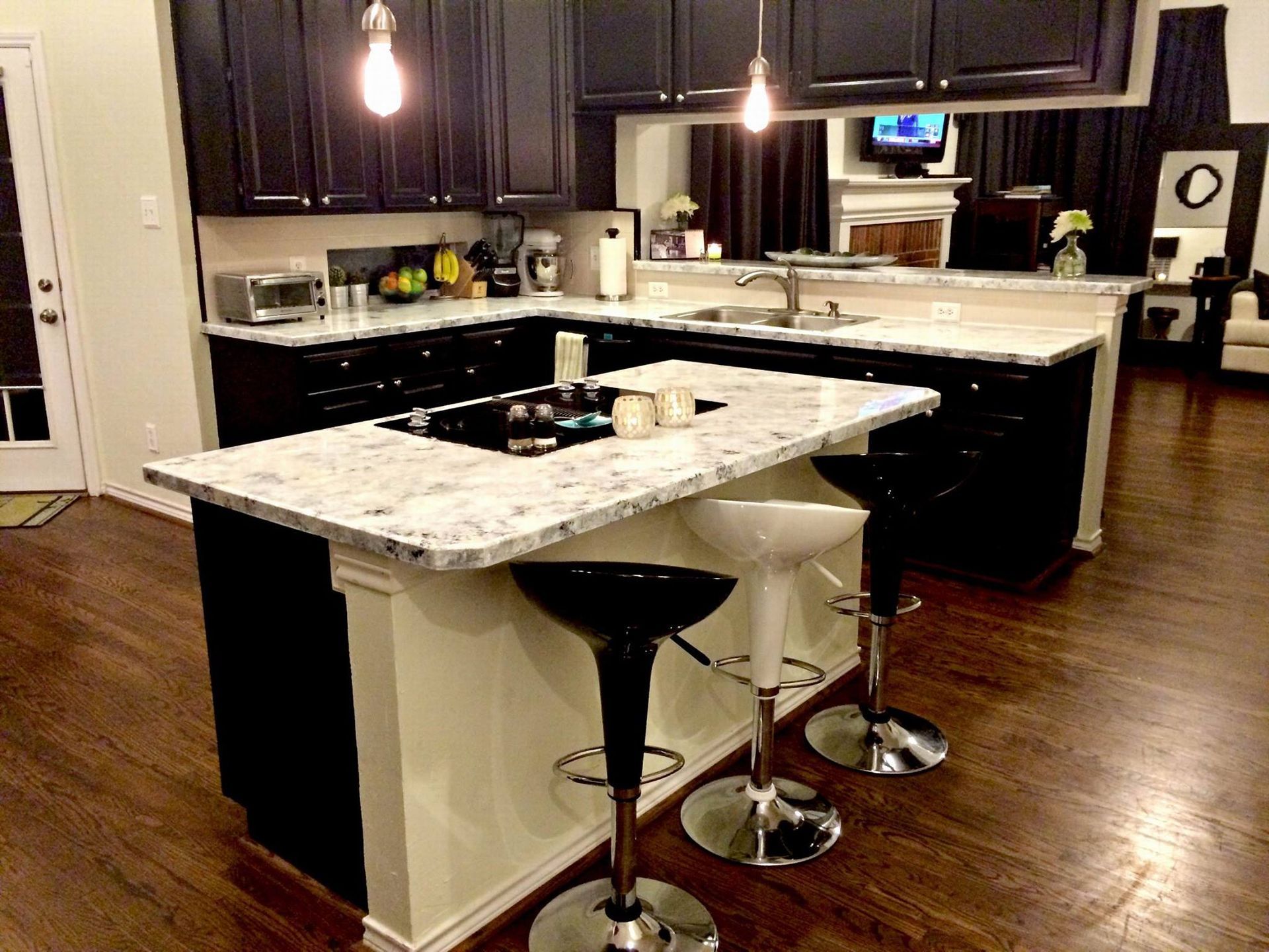 A kitchen with black cabinets and white counter tops