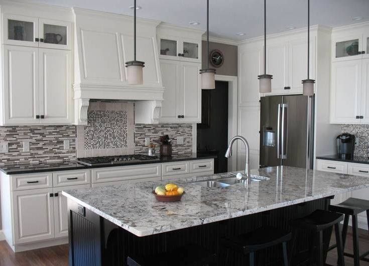 A kitchen with white cabinets , granite counter tops , stainless steel appliances and a large island.