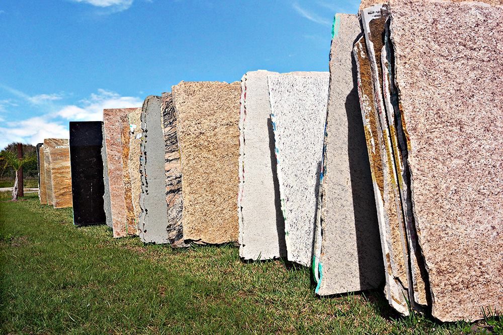 A row of granite slabs sitting on top of a lush green field.