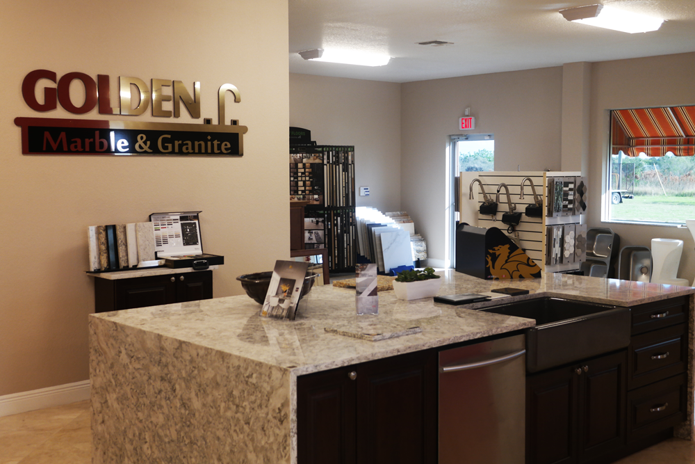 A kitchen with a large island and a sink in a store.