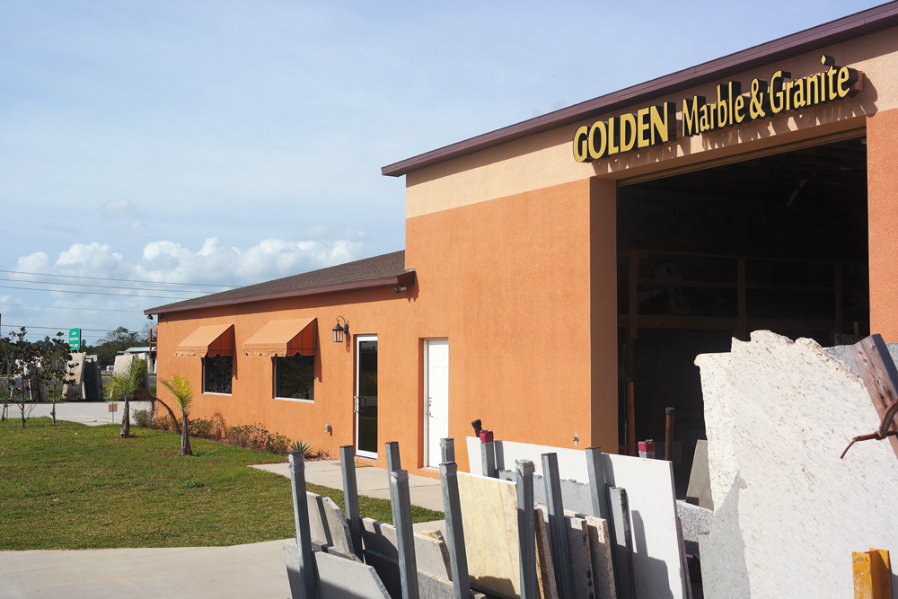 A building with a sign that says golden marble & granite
