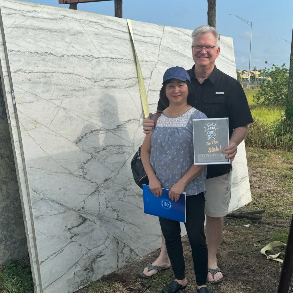 A man and a woman are standing in front of a large marble slab