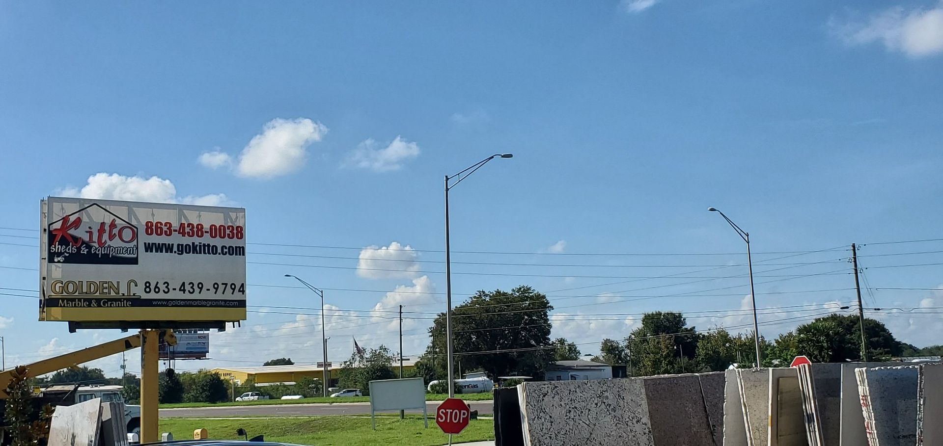 A billboard for a carpet cleaning company is above a stop sign