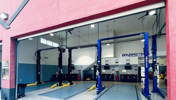 A green car is on a lift in a garage