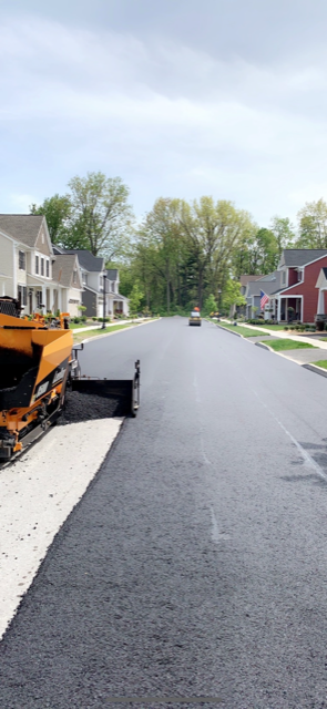 A road is being paved in a residential neighborhood.