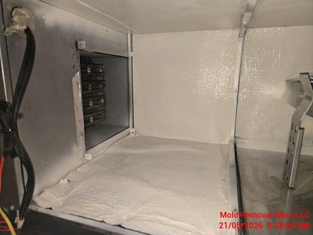 White insulated compartment with an open vent and wiring in a metal enclosure, viewed from inside.