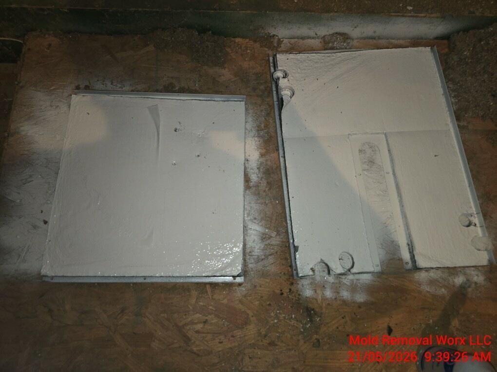 Two white wall-mounted panels in a rough, unfinished brown wall opening.