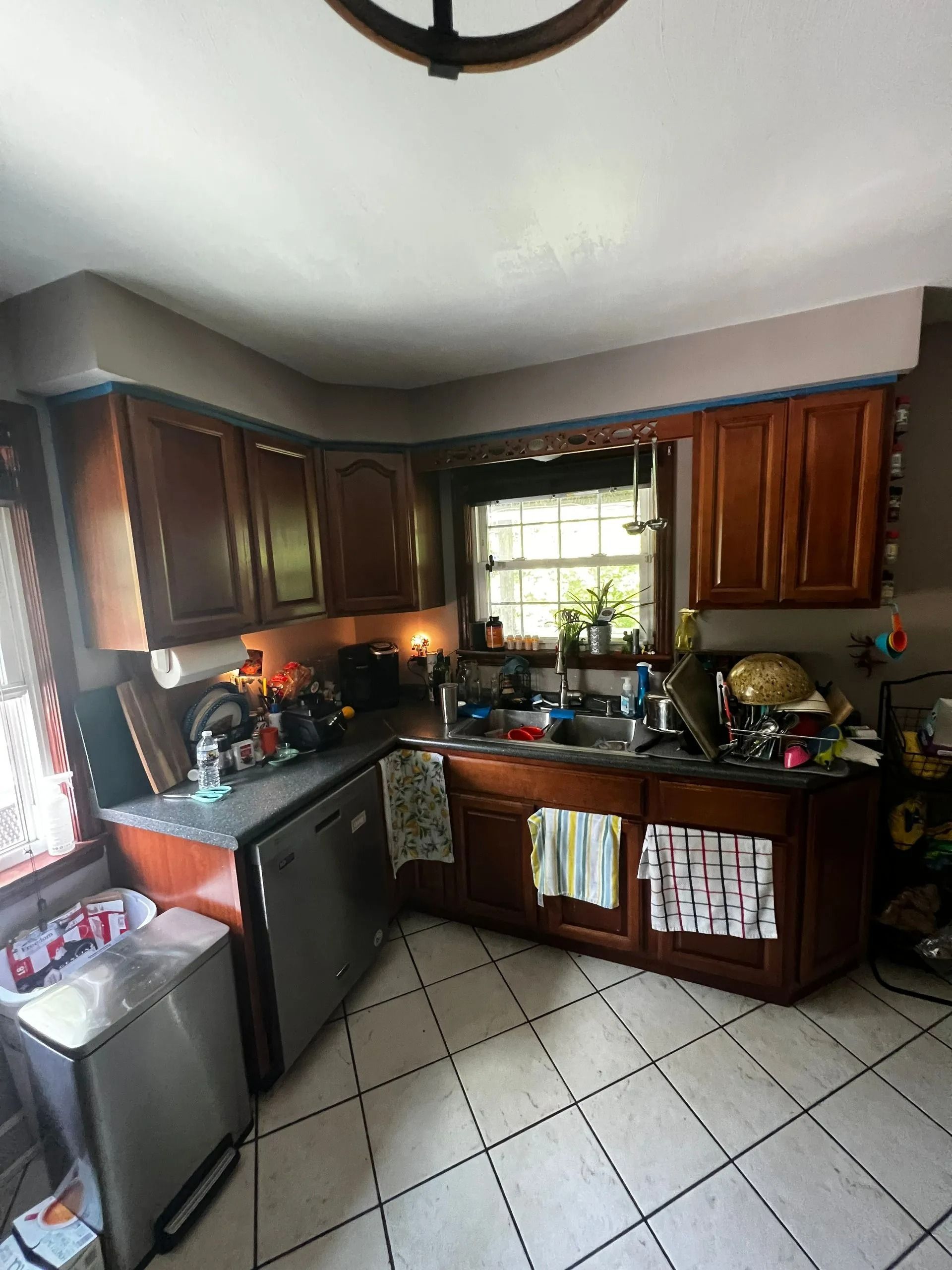 Kitchen with dark wood cabinets, stainless steel appliances, and tiled floor.