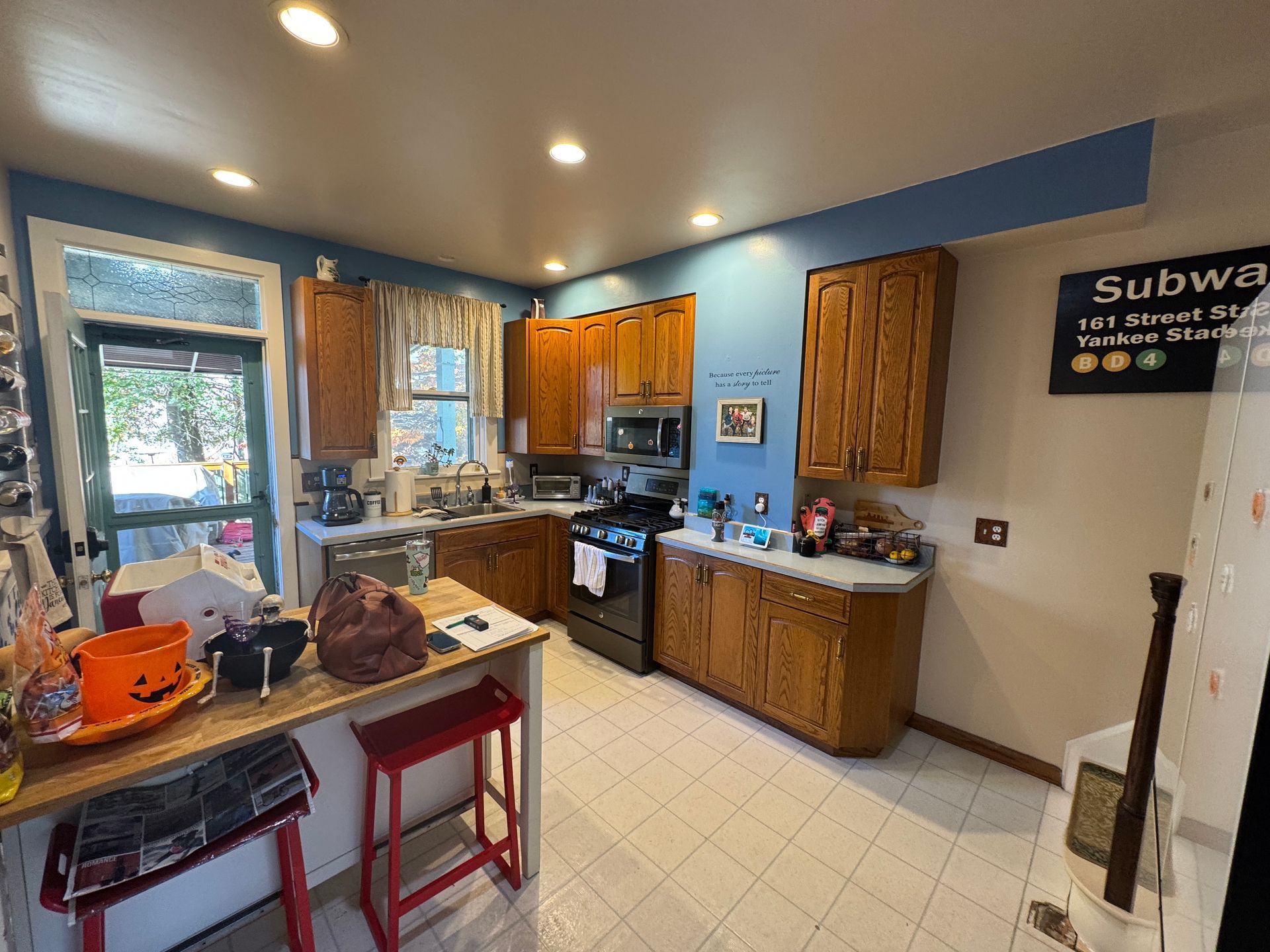 Kitchen with wood cabinets, blue walls, a breakfast bar, and tiled floor.