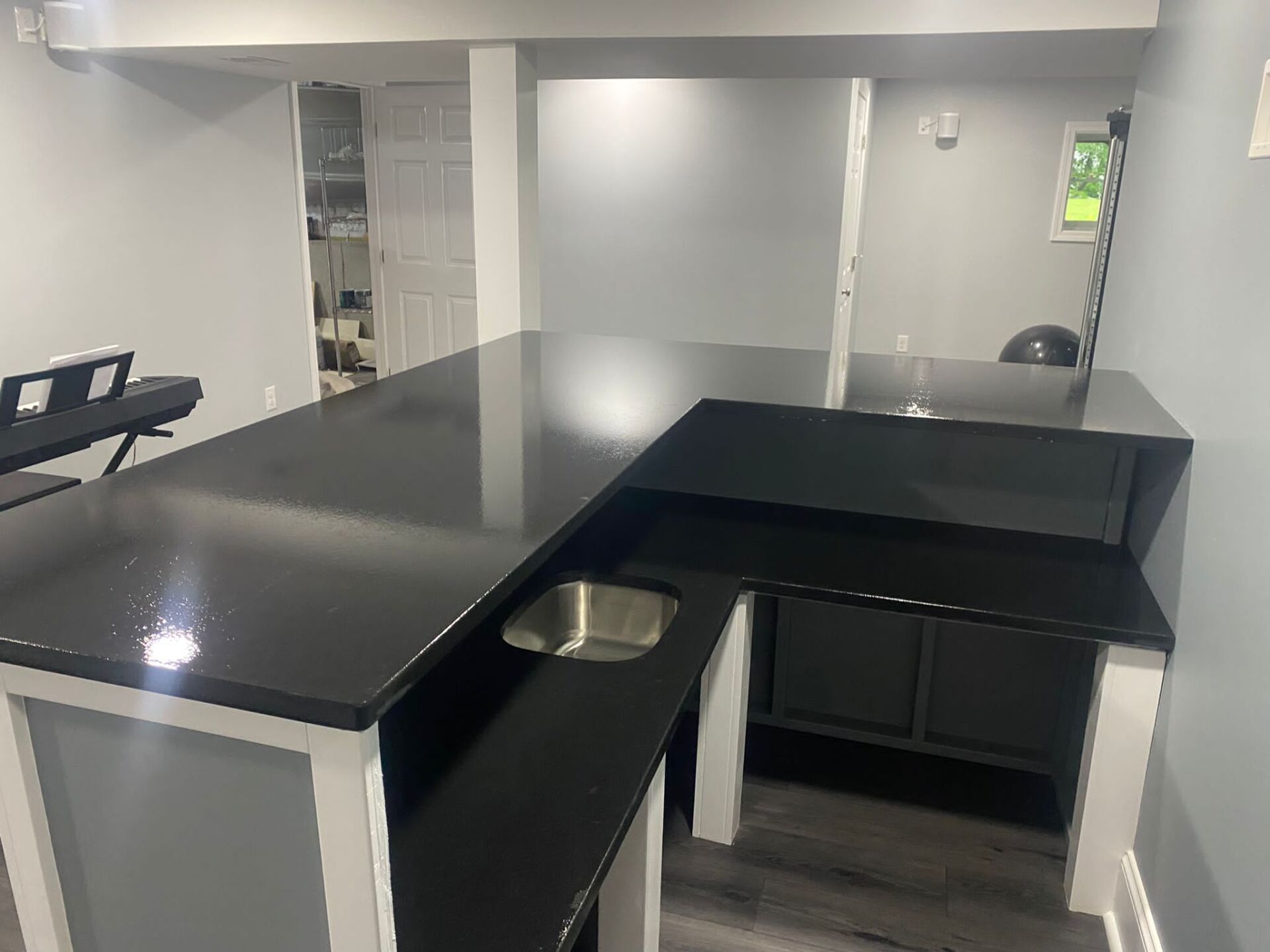 A kitchen with a black counter top and a sink.