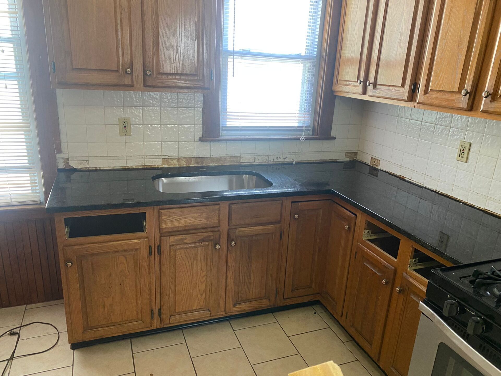 A kitchen with wooden cabinets and a black counter top