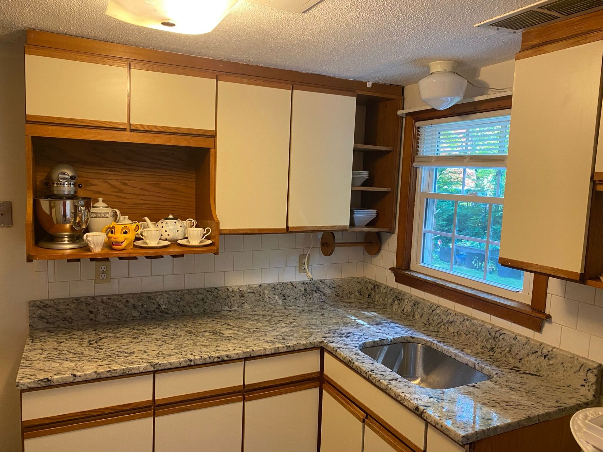 A kitchen with granite counter tops and a stainless steel sink