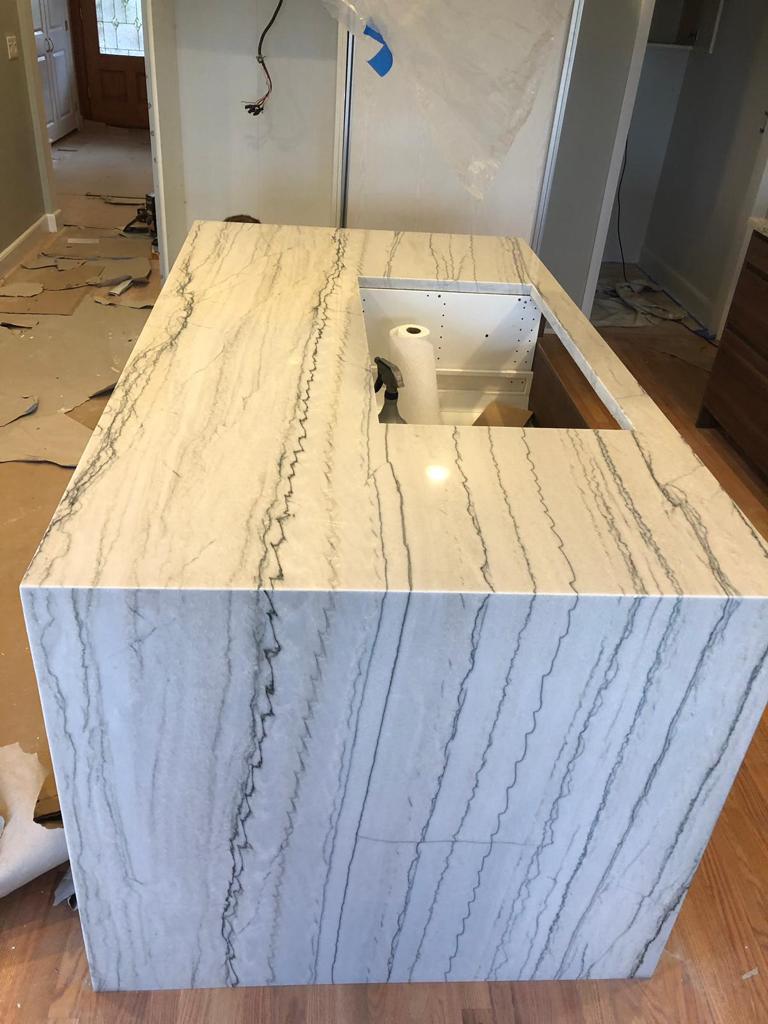 A white granite counter top with a sink in a kitchen.
