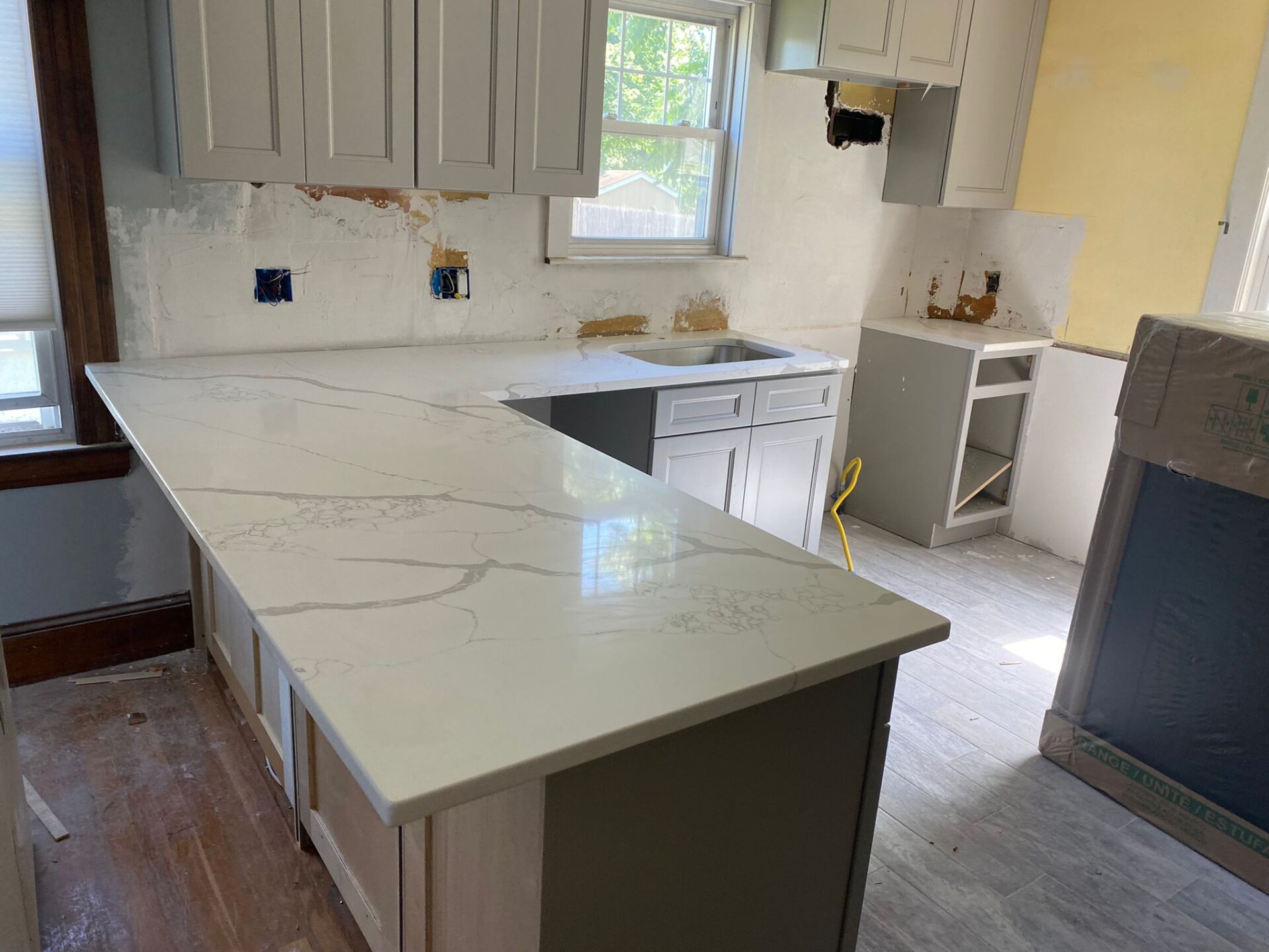 A kitchen with white cabinets and a white counter top.
