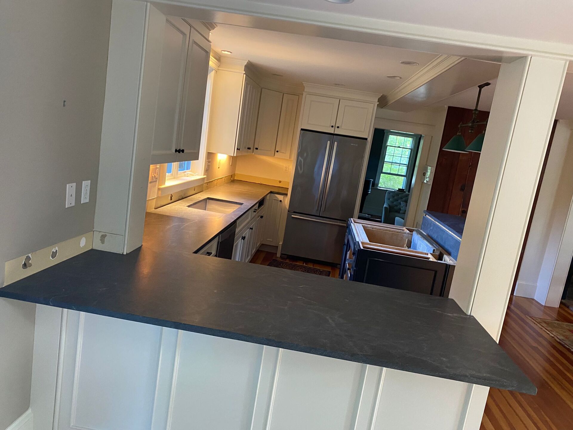 A kitchen with a black counter top and white cabinets