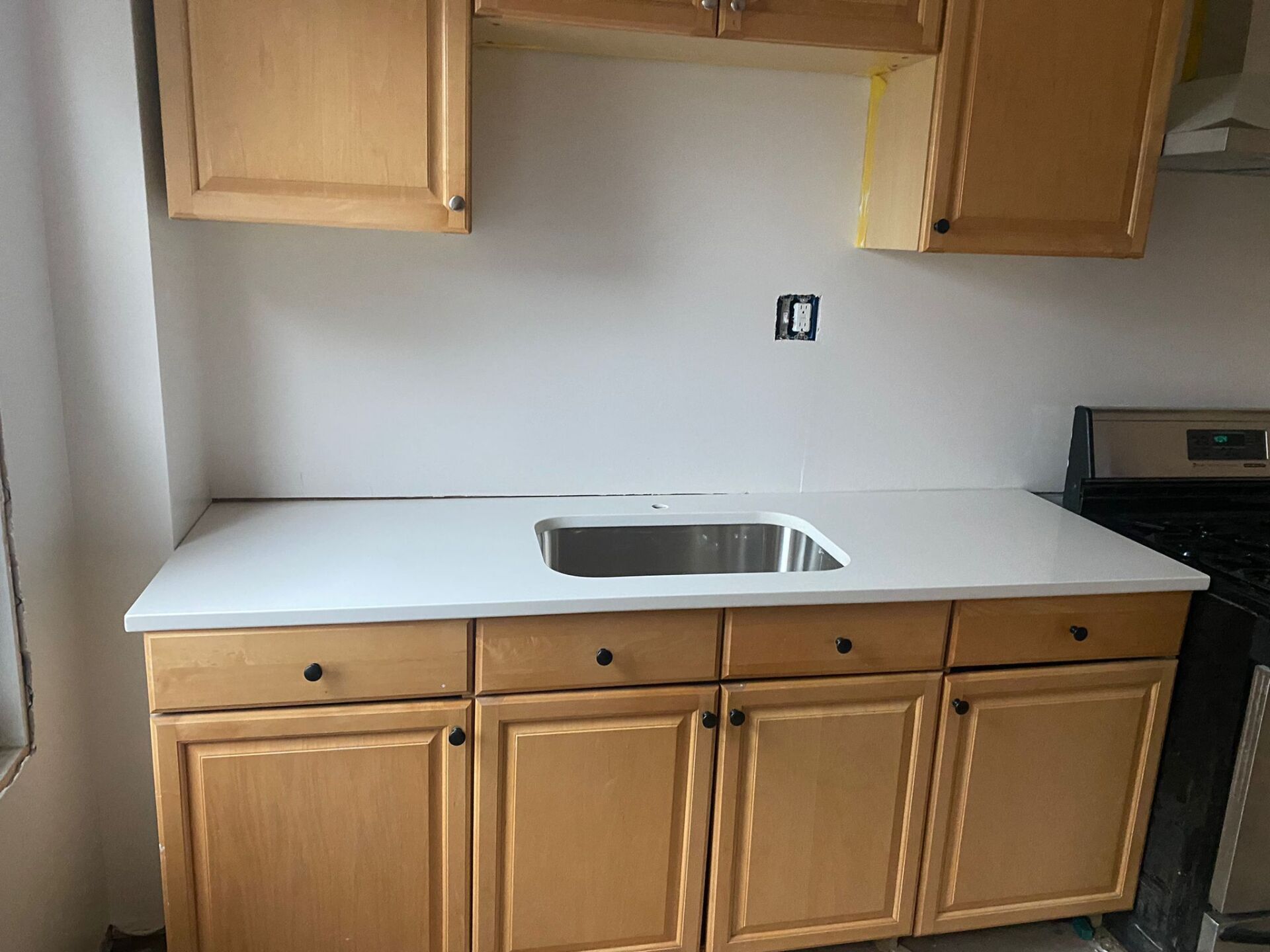 A kitchen with wooden cabinets and a stainless steel sink