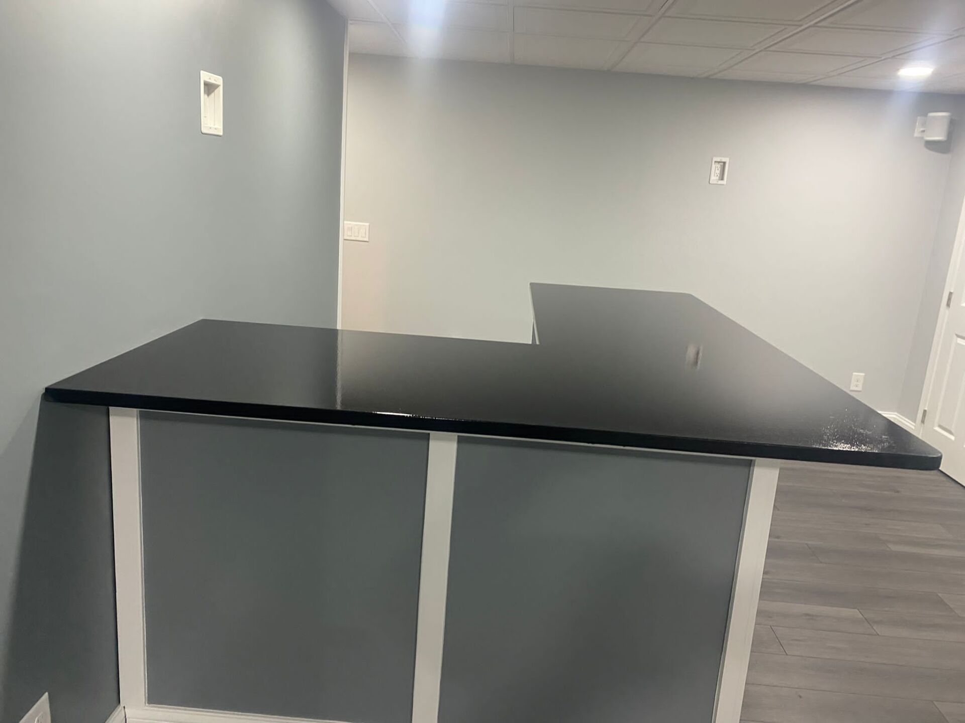 There is a black counter top in the middle of the room.