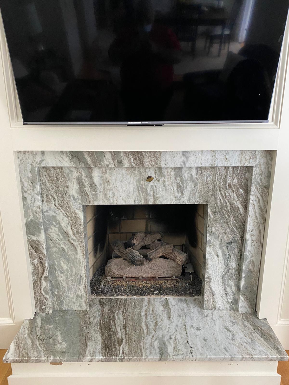 A fireplace with a flat screen tv above it.