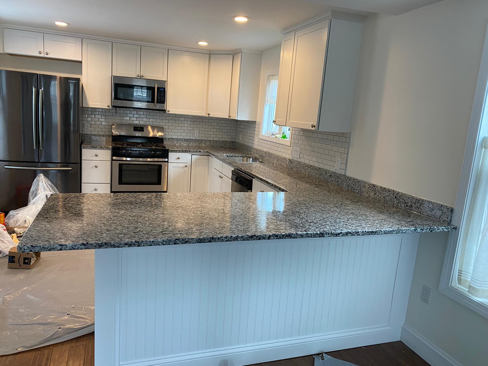A kitchen with granite counter tops and stainless steel appliances.