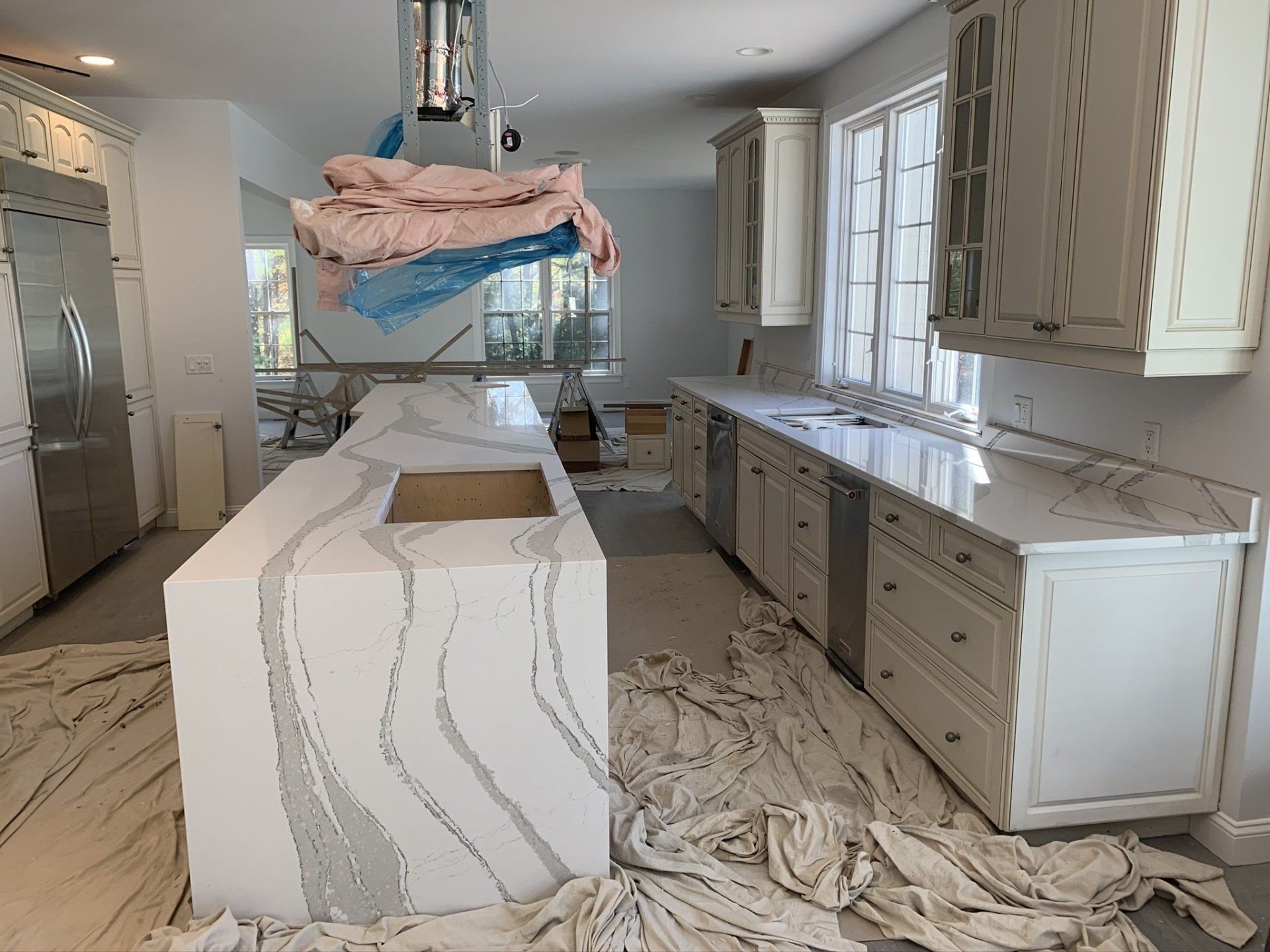 A kitchen under construction with a large island in the middle