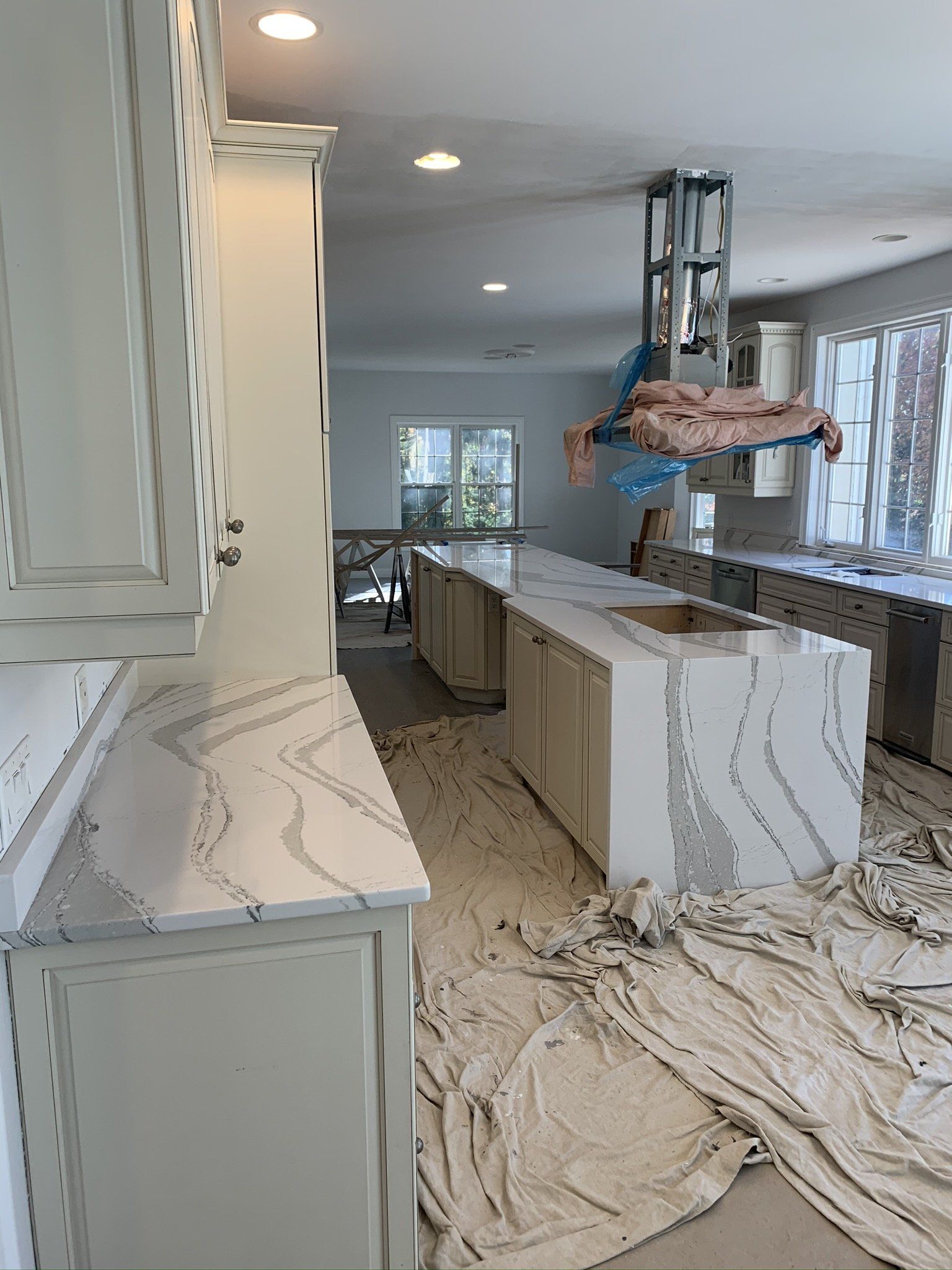 A kitchen with white cabinets and white counter tops is being remodeled.