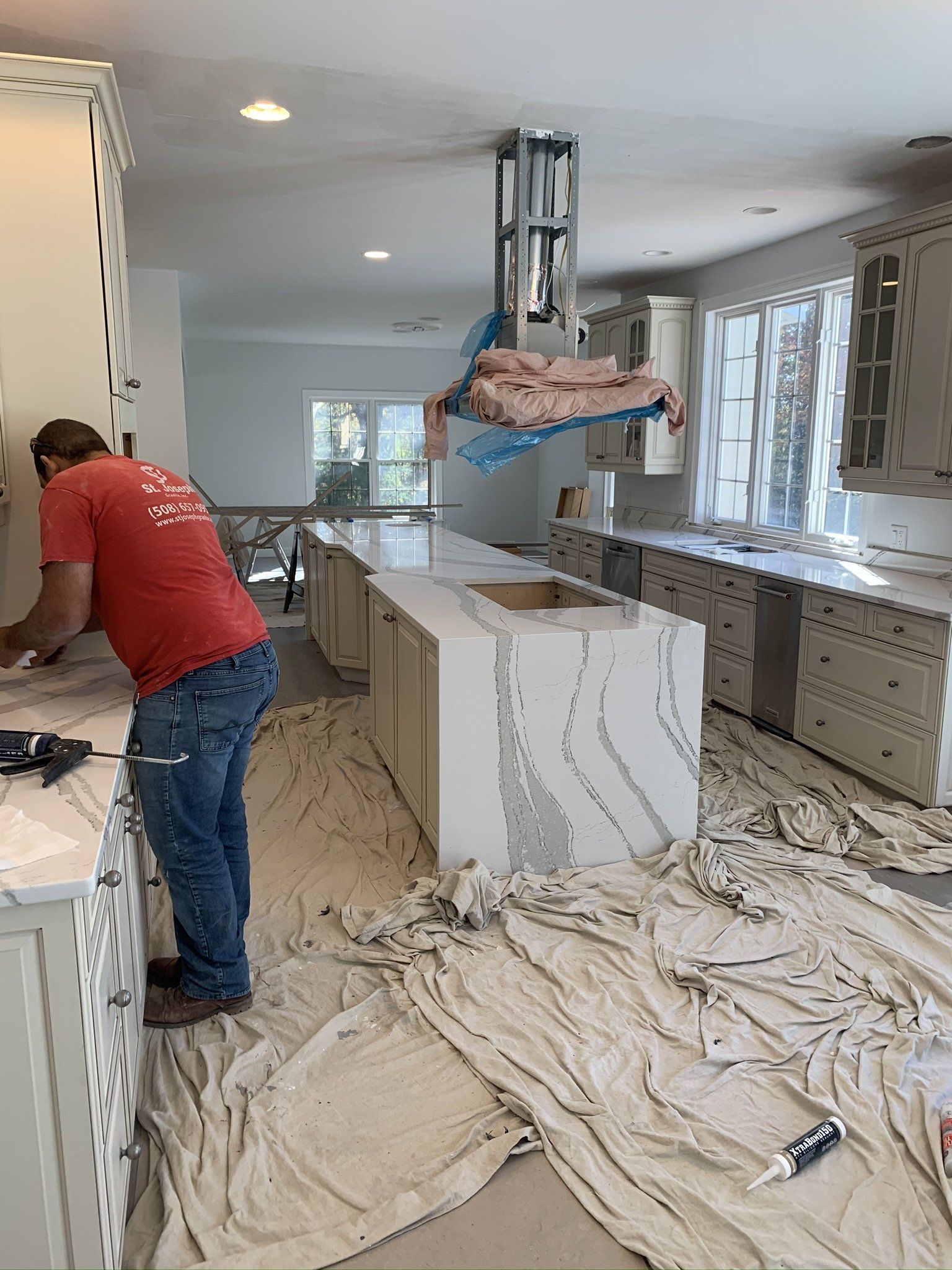 A man in a red shirt is working in a kitchen.