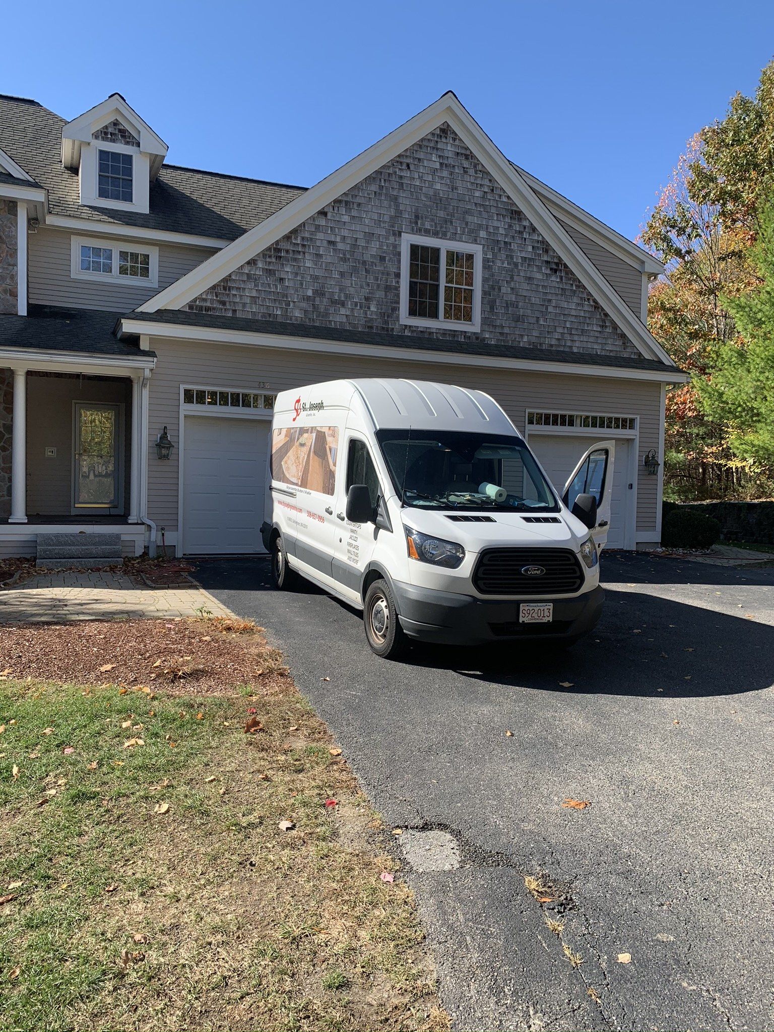 A white van is parked in front of a house.