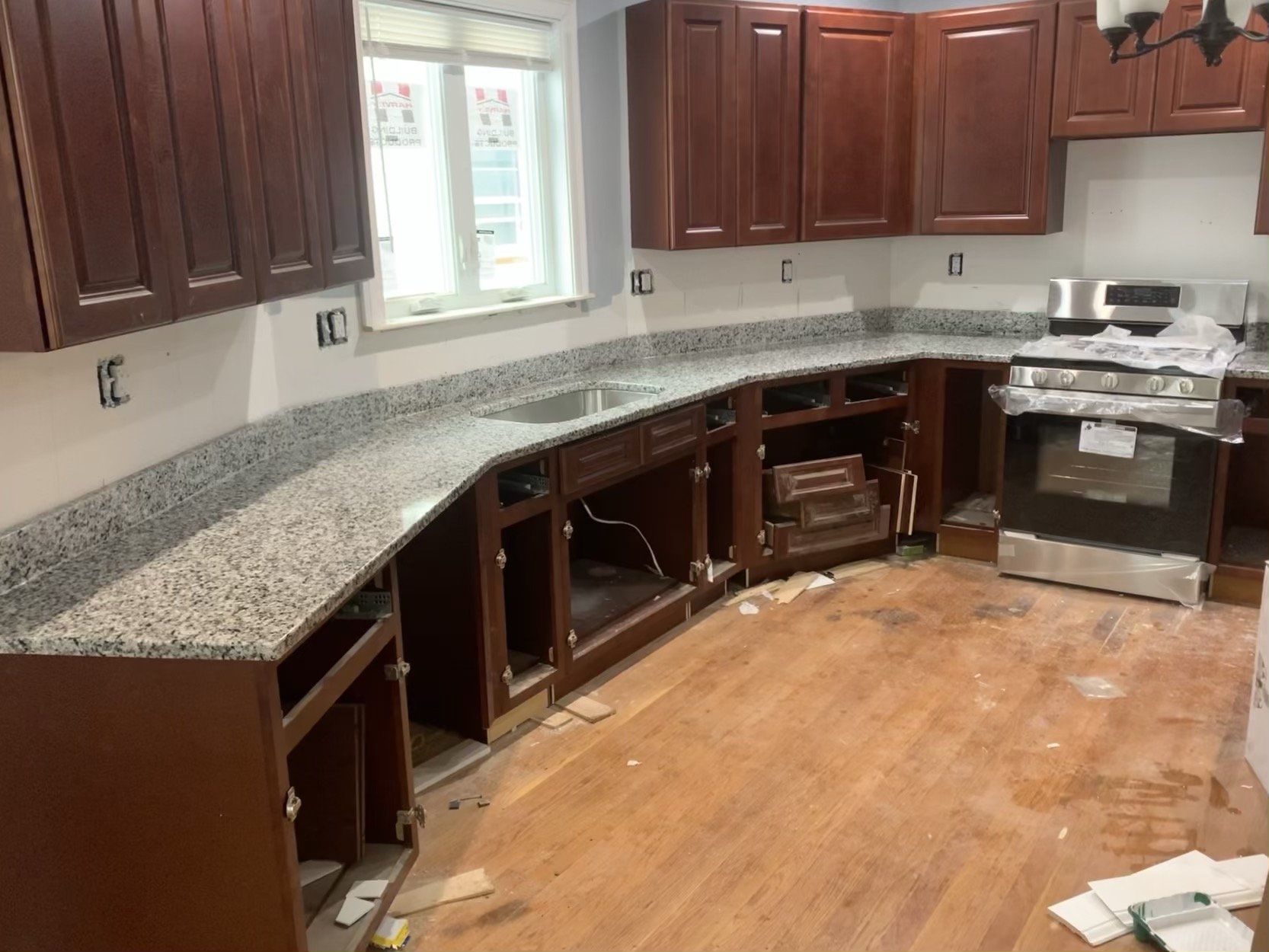A kitchen with wooden cabinets and granite counter tops is being remodeled.