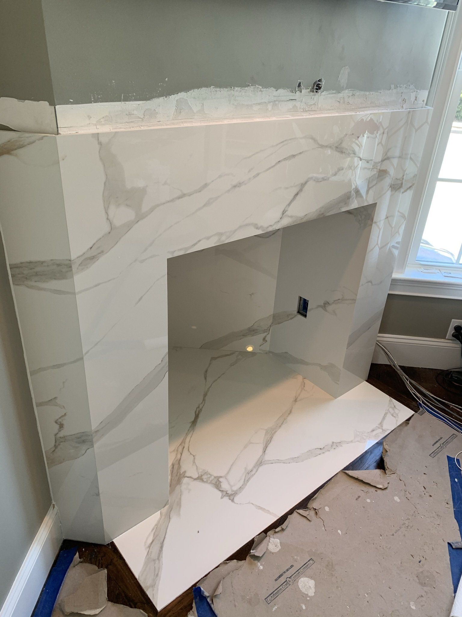 A marble fireplace is being remodeled in a living room.